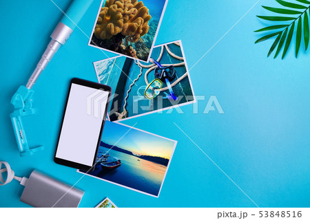 Smartphone with blank screen, flyers, photos on blue background. Mock up, flat lay. Summer concept Smartphone with blank screen, flyers, photos on blue background. Mock up, flat lay. Summer concept 53848516