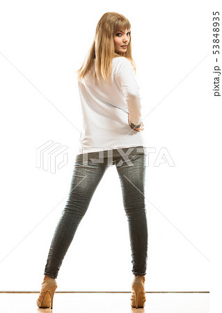 woman in denim pants high heels shoes back view 53848935