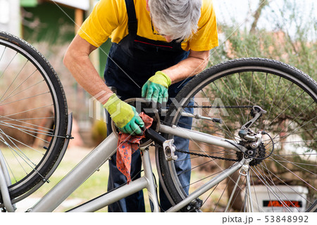 Man cleaning his bicycle for the new season Man cleaning his bicycle for the new season 53848992