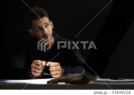 Criminal man with handcuffs in interrogation room Criminal man with handcuffs in interrogation room 53849228