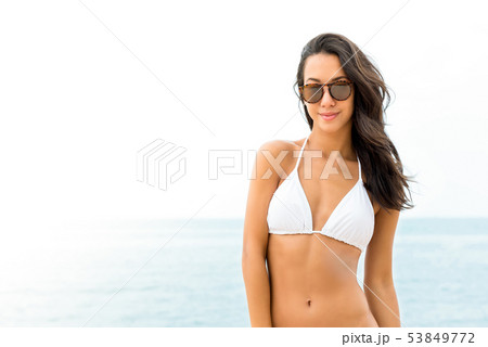 Young beautiful Asian woman in white swimsuit Young beautiful Asian woman in white swimsuit 53849772