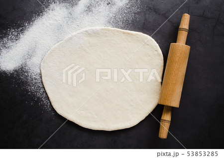 Rolled dough, baking flour and rolling pin on a 53853285