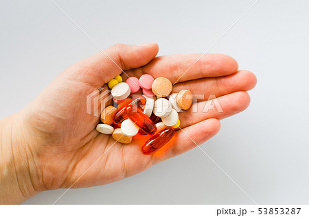 Assorted colorful tablets, pills, drugs in hand on 53853287