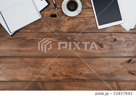 Top view of brown wooden table with office supplies on it 53857692