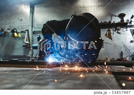 Weld Done Well. Man welds at the factory 53857997