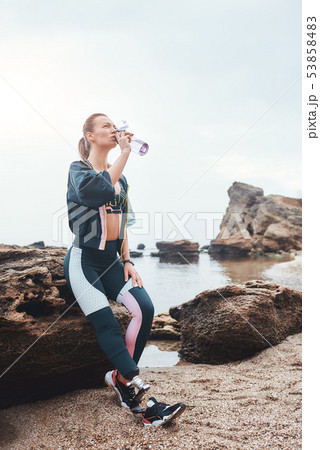 I need some water. Sporty and healthy disabled athlete woman with prosthetic leg drinking water 53858483