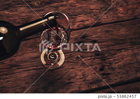 Pouring Red wine bottle and glass of wine on a Pouring Red wine bottle and glass of wine on a 53862457