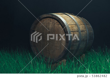 Old woden barrel in grass on a dark background. 53862482