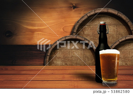 Wooden barrel background and glass of beer on a 53862580