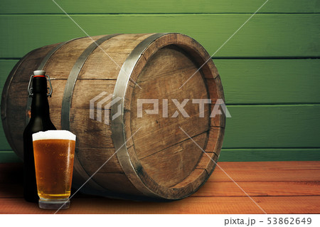Wooden barrel, glass of beer and black bottle on a Wooden barrel, glass of beer and black bottle on a 53862649