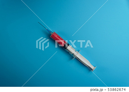 Syringe filled with colorful nano balls on a blue 53862674