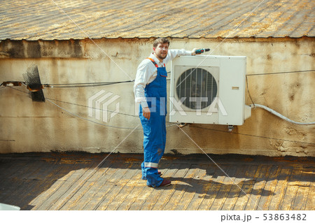HVAC technician working on a capacitor part for condensing unit 53863482