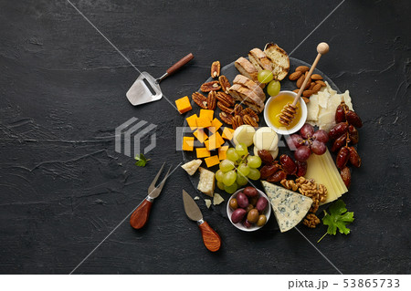 Top view of tasty cheese plate with fruit on the black stone Top view of tasty cheese plate with fruit on the black stone 53865733