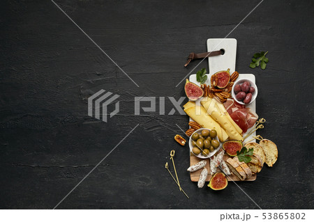 Top view of tasty cheese plate with the fruit on the black stone 53865802