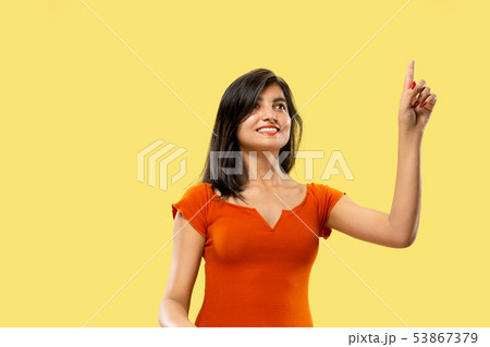 Portrait of beautiful woman isolated on yellow studio background 53867379