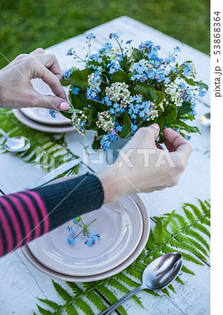 Top view florist makes a bouquet of forget-me-not 53868364