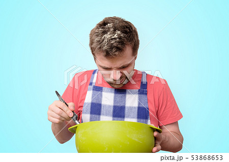 Man holds kitchenware cooking with curious face 53868653