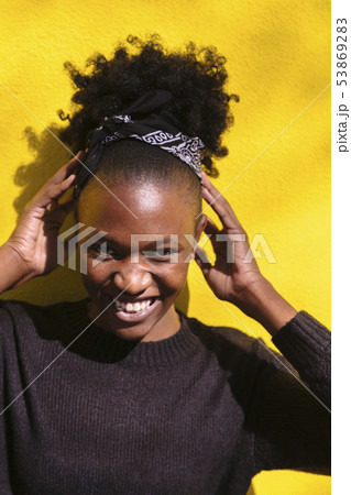 Young african girl fixes her hair and laughs 53869283