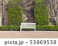 Elegant wooden white bench by trimmed green hedge 53869538