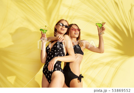 Beautiful girls isolated on yellow studio background Beautiful girls isolated on yellow studio background 53869552