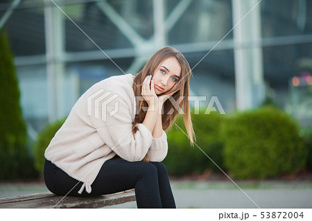 Depressed woman sitting in a city park on a bench Depressed woman sitting in a city park on a bench 53872004