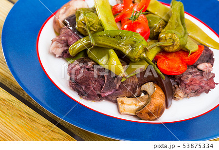 Tasty stewed lamb cooked with different vegetables served at plate 53875334