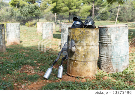 Protective masks and marker guns on paintball field Protective masks and marker guns on paintball field 53875496
