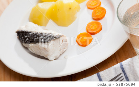 Cod prepared on steam with with carrots and potatoes, served at plate Cod prepared on steam with with carrots and potatoes, served at plate 53875694