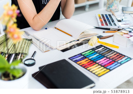 Close-up angle view of a female painter drawing draft at sketchbook using pencil. Artist sketching 53878913