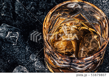 Whiskey with ice on stone dark background. 53879807