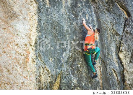 Woman climbs rock. Woman climbs rock. 53882358