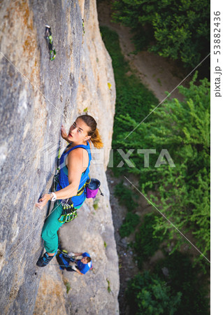 Woman climbs rock. Woman climbs rock. 53882436