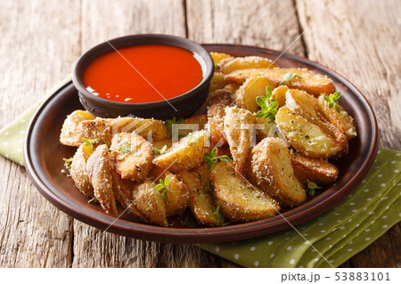 Delicious snack of potato wedges with parmesan Delicious snack of potato wedges with parmesan 53883101
