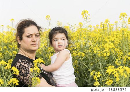 Serious mother embraced her little girl at canola Serious mother embraced her little girl at canola 53883575