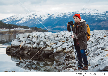 Travel photographer man taking nature video of mountain landscape. Professional videographer on Travel photographer man taking nature video of mountain landscape. Professional videographer on 53883671