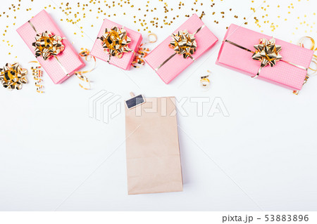 Paper bag next to festive pink gift boxes Paper bag next to festive pink gift boxes 53883896