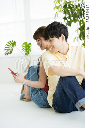 スマホを見る男女 53886412