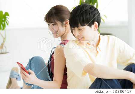 スマホを見る男女 53886417