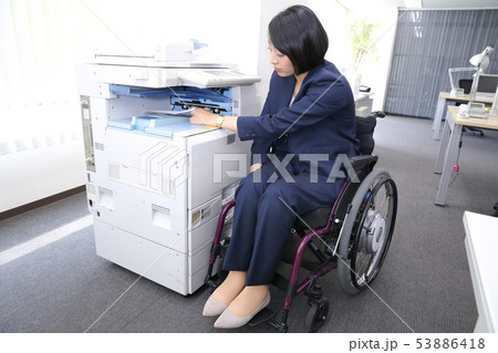 コピーを取る車椅子の従業員 53886418