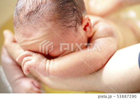 薬草の煎じ汁を入れたお風呂に浸かる生後2週間の赤ちゃんの背中を洗う 薬草の煎じ汁を入れたお風呂に浸かる生後2週間の赤ちゃんの背中を洗う 53887290