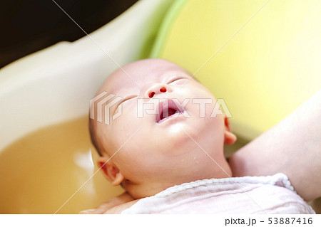 薬草の煎じ汁を入れたベビーバスに浸かってウトウトする生後2週間の赤ちゃん 53887416
