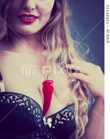 Woman wearing lingerie holding chilli pepper Woman wearing lingerie holding chilli pepper 53890533