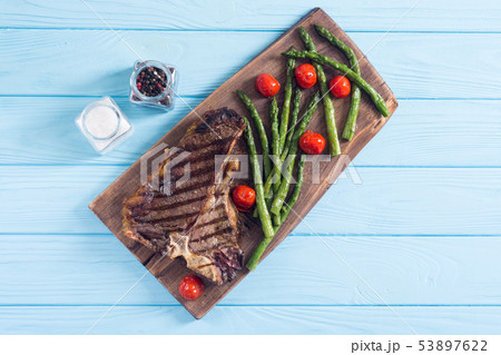 Grilled T-bone steak with asparagus and cherry Grilled T-bone steak with asparagus and cherry 53897622