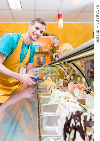 Ice cream seller in his shop at the counter 53898175