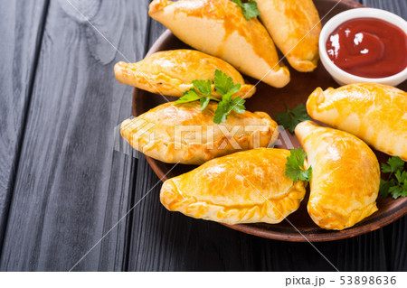 Latin American baked beef empanadas with sauce 53898636