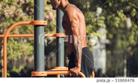 Muscular Man Doing Triceps Dips On Parallel Bars 53900476