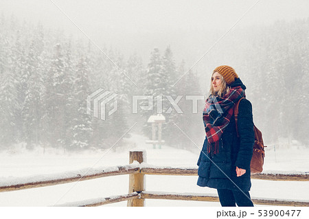 A young girl is having a walk through a thick forest during a beautiful winter day A young girl is having a walk through a thick forest during a beautiful winter day 53900477