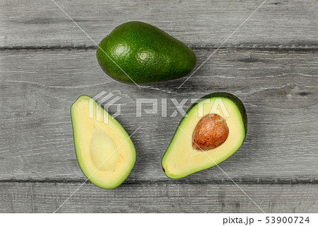 Table top view on avocado cut in half, with whole 53900724