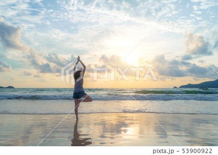 Happy Asian woman practicing yoga or exercising at 53900922