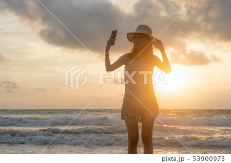 Happy Asian woman taking a selfie to post on Happy Asian woman taking a selfie to post on 53900973